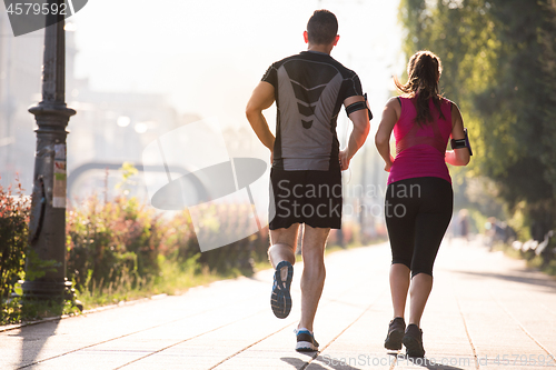 Image of young couple jogging  in the city