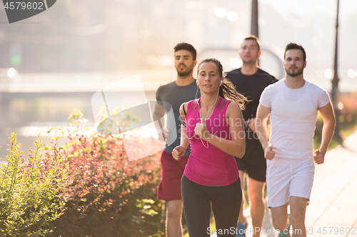 Image of group of young people jogging in the city