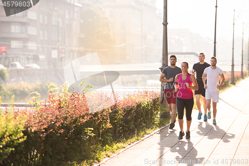 Image of group of young people jogging in the city