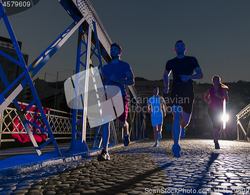 Image of young people jogging across the bridge