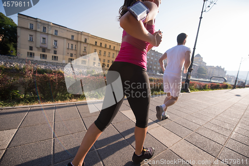 Image of young couple jogging  in the city