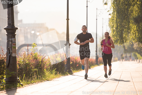 Image of young couple jogging  in the city