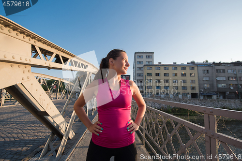 Image of portrait of a jogging woman at sunny morning