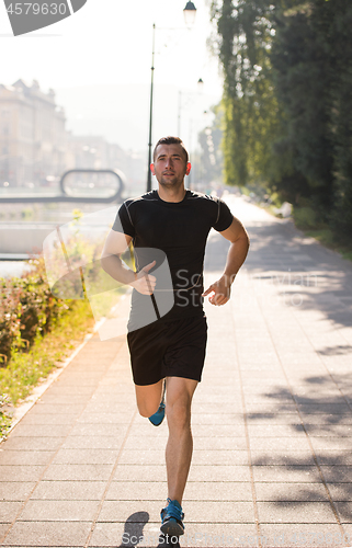 Image of man jogging at sunny morning