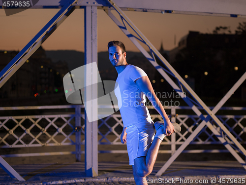 Image of man jogging across the bridge in the city