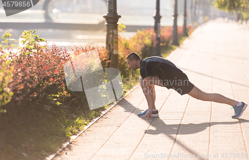Image of athlete man warming up and stretching