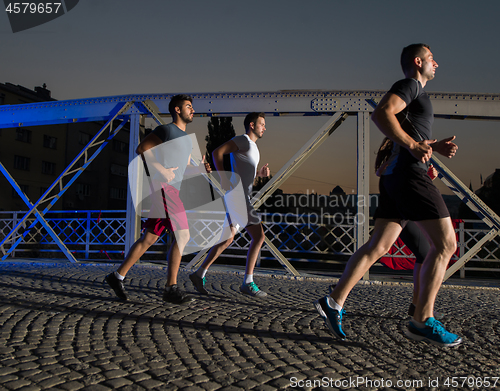 Image of young people jogging across the bridge