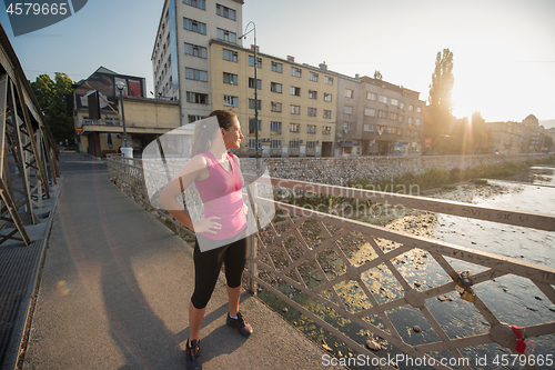 Image of portrait of a jogging woman at sunny morning