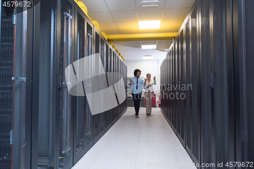 Image of engineer showing working data center server room to female chief