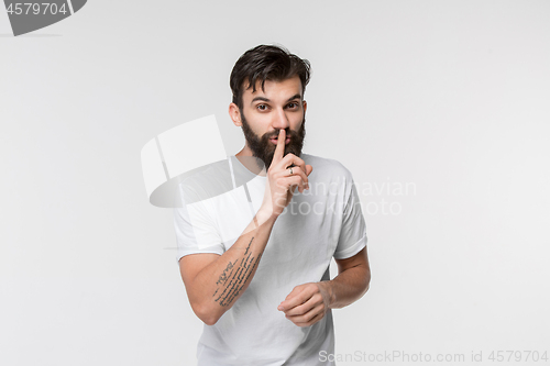 Image of The young man whispering a secret behind her hand