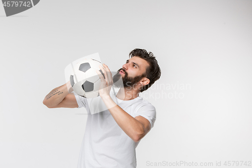 Image of Young soccer player with ball in front of white background