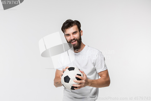 Image of Young soccer player with ball in front of white background