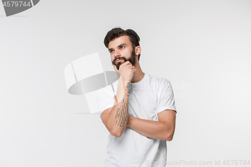 Image of Young serious thoughtful businessman. Doubt concept.