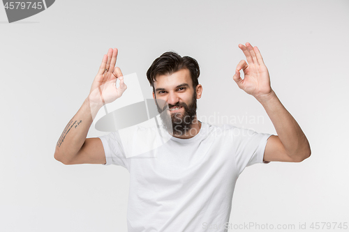 Image of The happy businessman standing and smiling against white background.