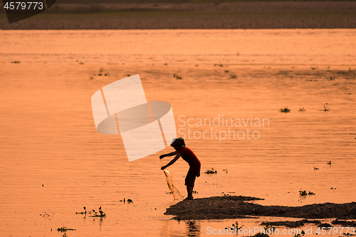 Image of Asian Woman fishing in the river, silhouette at sunset