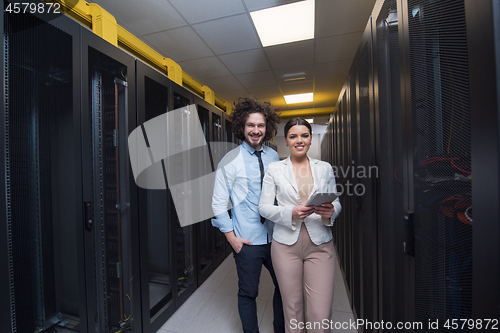 Image of engineer showing working data center server room to female chief