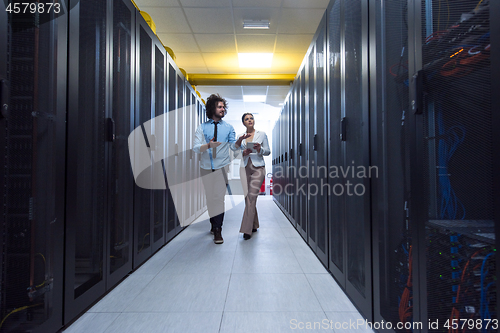 Image of engineer showing working data center server room to female chief