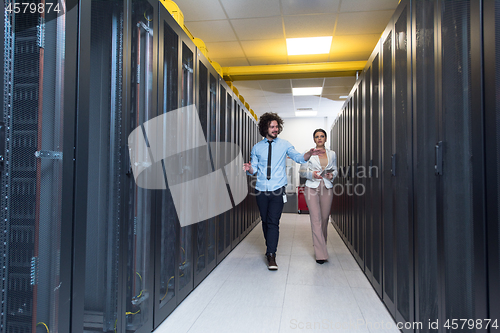 Image of engineer showing working data center server room to female chief