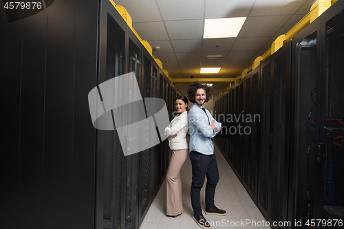 Image of engineer showing working data center server room to female chief