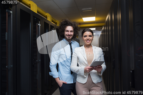 Image of engineer showing working data center server room to female chief