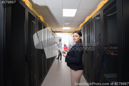 Image of Female engineer working on a tablet computer in server room