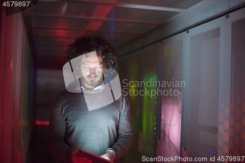 Image of IT engineer working on a tablet computer in server room