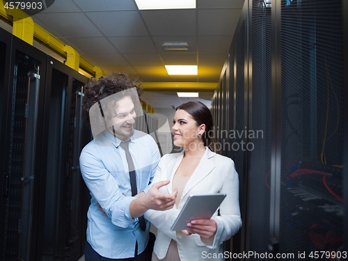 Image of engineer showing working data center server room to female chief