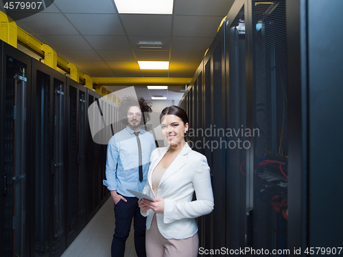 Image of engineer showing working data center server room to female chief