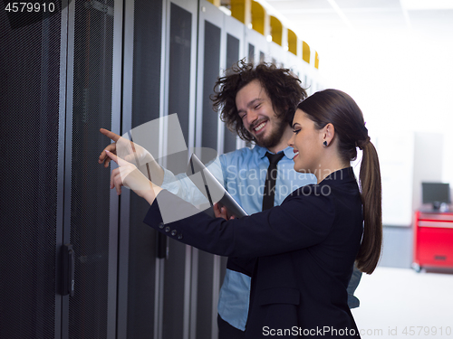 Image of engineer showing working data center server room to female chief