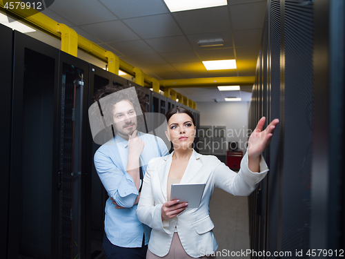 Image of engineer showing working data center server room to female chief