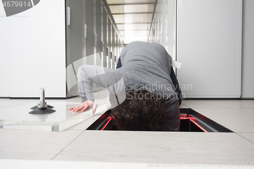 Image of engineer connecting cables in server room