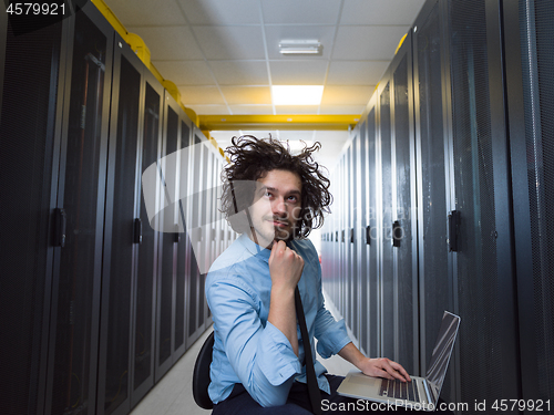 Image of engineer working on a laptop in server room