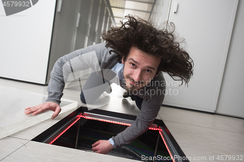 Image of engineer connecting cables in server room