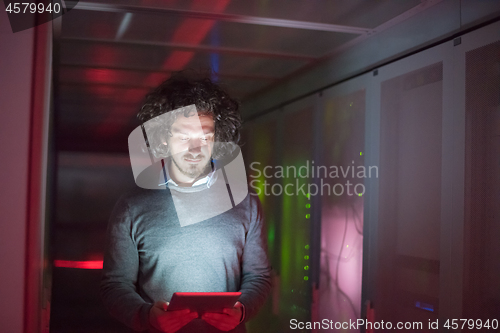 Image of IT engineer working on a tablet computer in server room