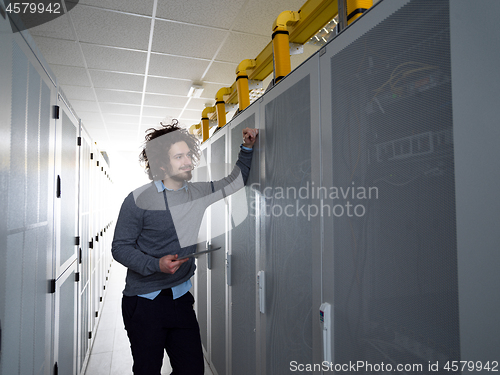 Image of IT engineer working on a tablet computer in server room