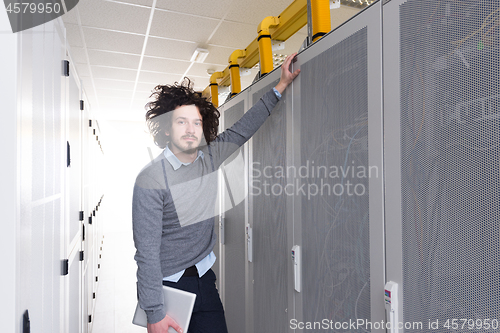 Image of IT engineer working on a tablet computer in server room