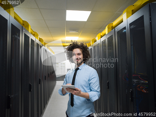 Image of IT engineer working on a tablet computer in server room