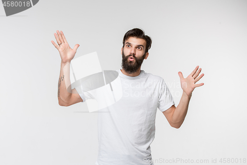 Image of The young attractive man looking suprised isolated on white