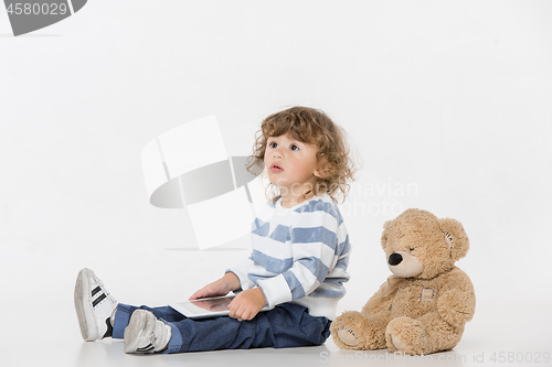 Image of Portrait of happy joyful beautiful little boy sitting with laptop