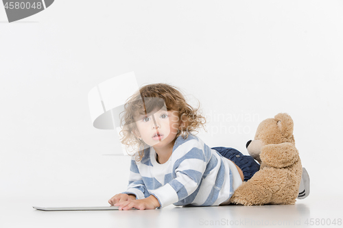 Image of Portrait of happy joyful beautiful little boy sitting with laptop
