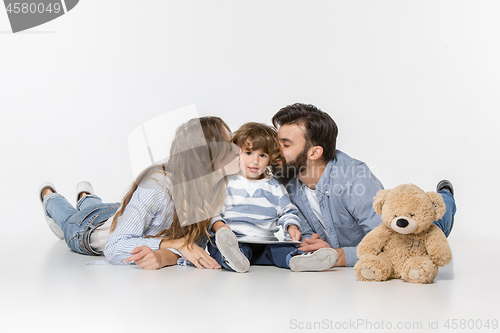 Image of Smiling family sitting together in studio and watching their favorite cartoons on laptop