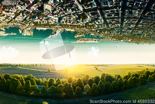 Image of Natural landscape with unreal upside down sityscape.