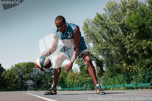 Image of Picture of young confused african basketball player practicing