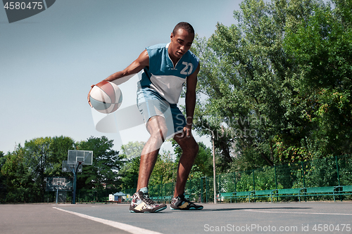 Image of Picture of young confused african basketball player practicing