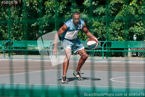 Image of Picture of young confused african basketball player practicing