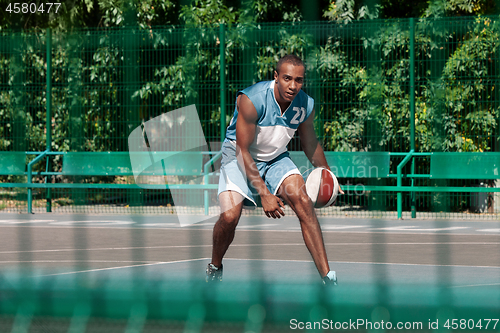 Image of Picture of young confused african basketball player practicing