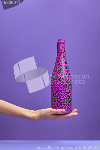 Image of Woman\'s hand holds painted hot pink and black spots.