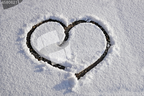 Image of Heart drawn on white clear thin snow
