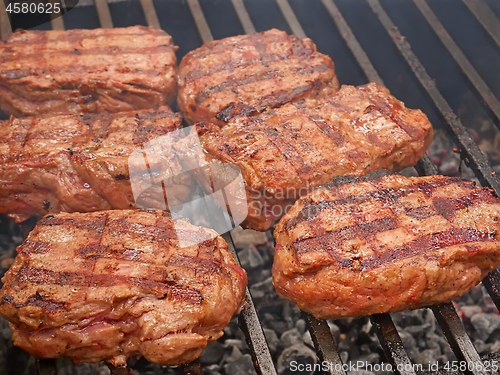 Image of Large pieces of meat are roasted on metal bars