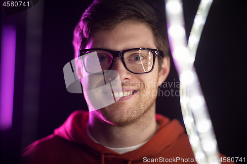 Image of portrait of man in glasses over neon lights